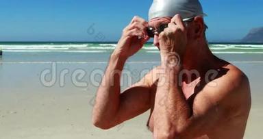 穿着<strong>泳镜</strong>的老人在海滩上